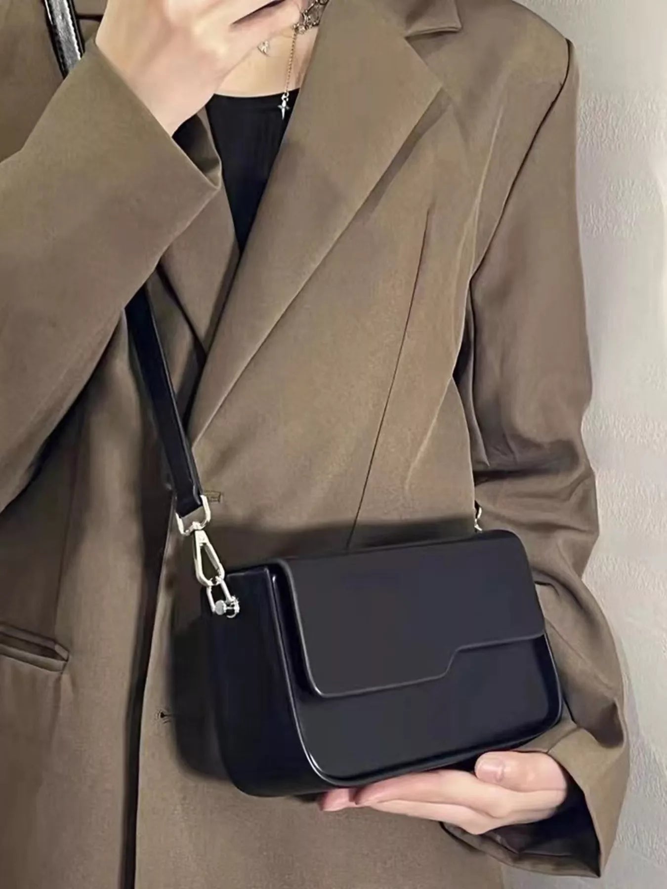 Woman wearing a minimalist black crossbody bag
