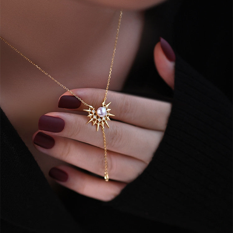 Gold necklace with a star-shaped pendant worn by a person