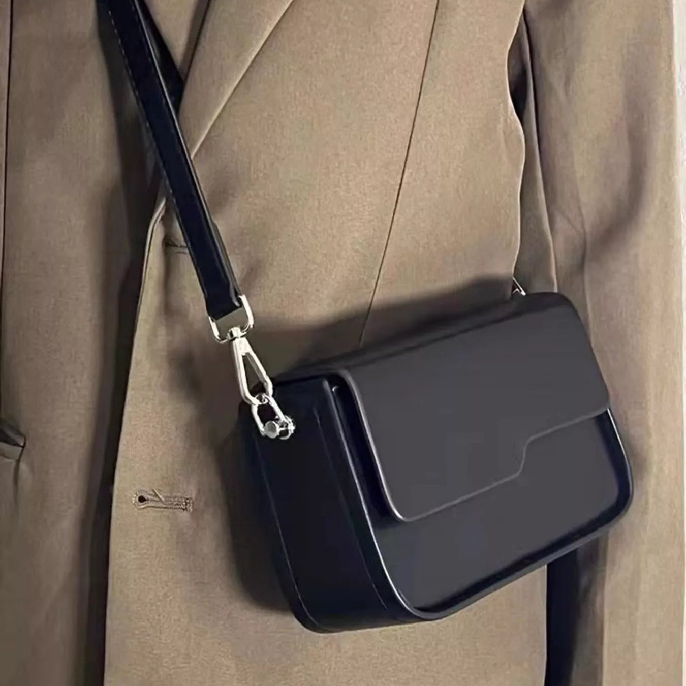 Minimal black flap crossbody bag with structured silhouette