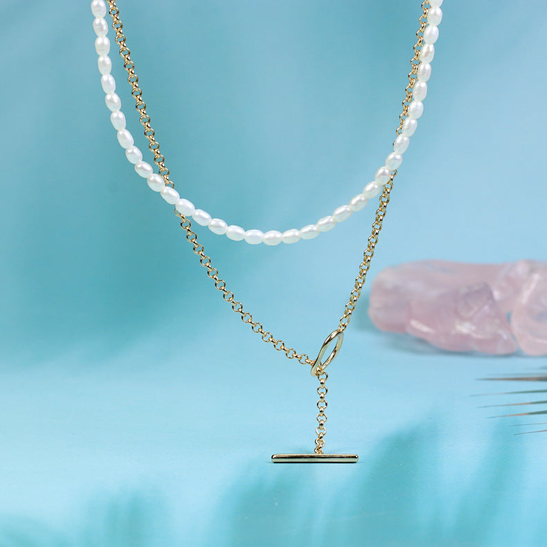 Two necklaces on a blue background with a pink crystal.