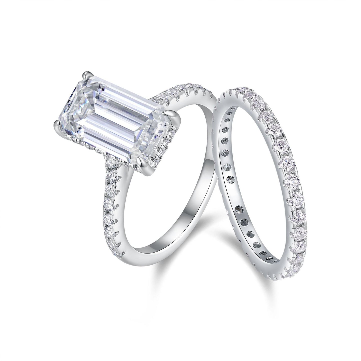 Diamond ring with emerald-cut center stone on a white background