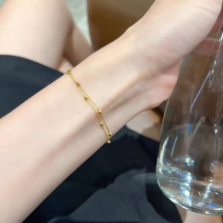 Gold bracelet on a wrist with a blurred background