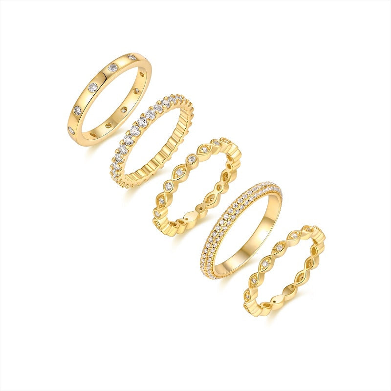 Set of gold rings with diamond accents on a white background