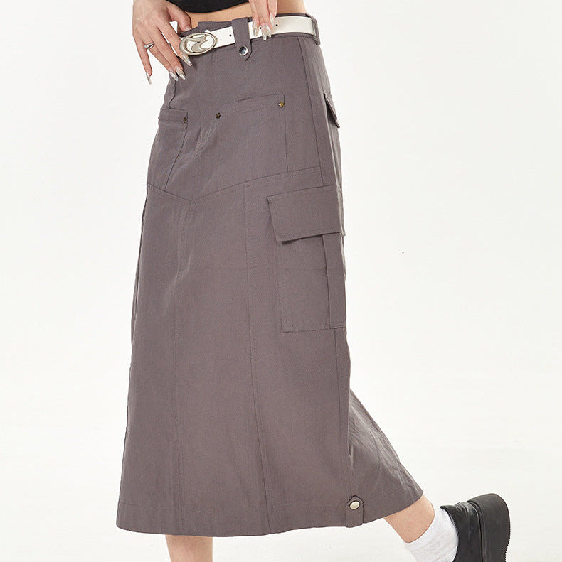 Person wearing a gray cargo skirt with black shoes on a white background
