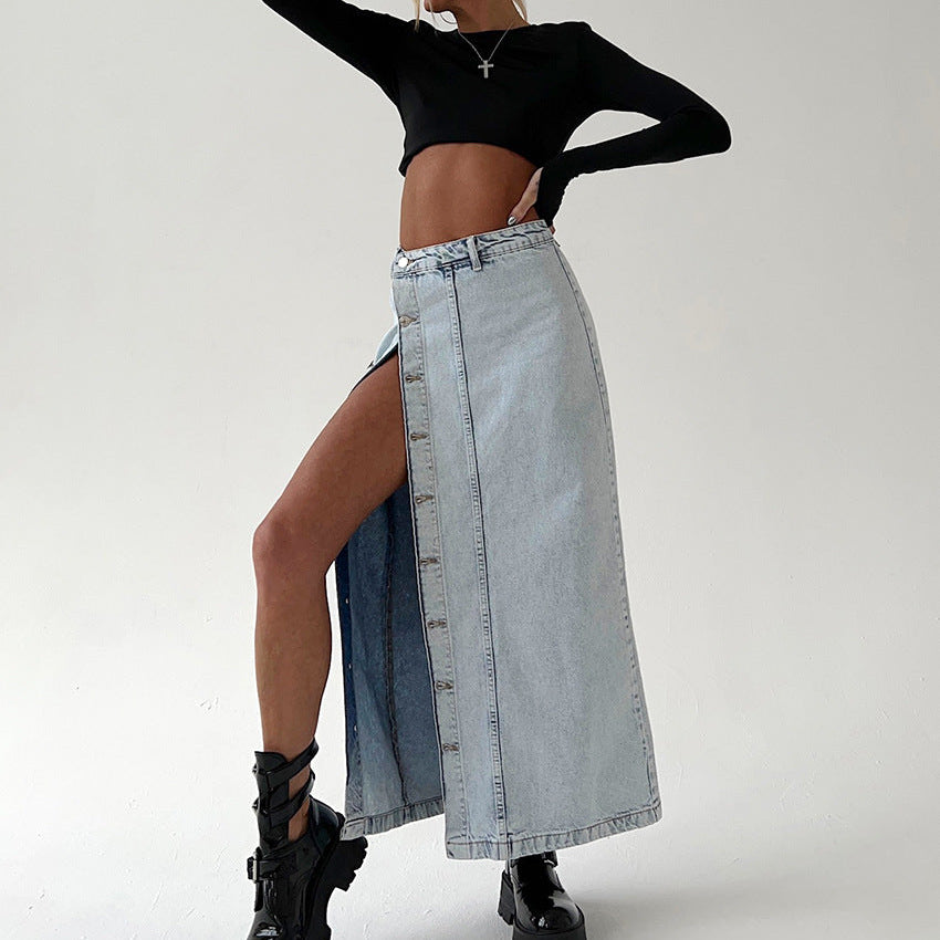 Person wearing a black long-sleeve top and denim skirt on a white background