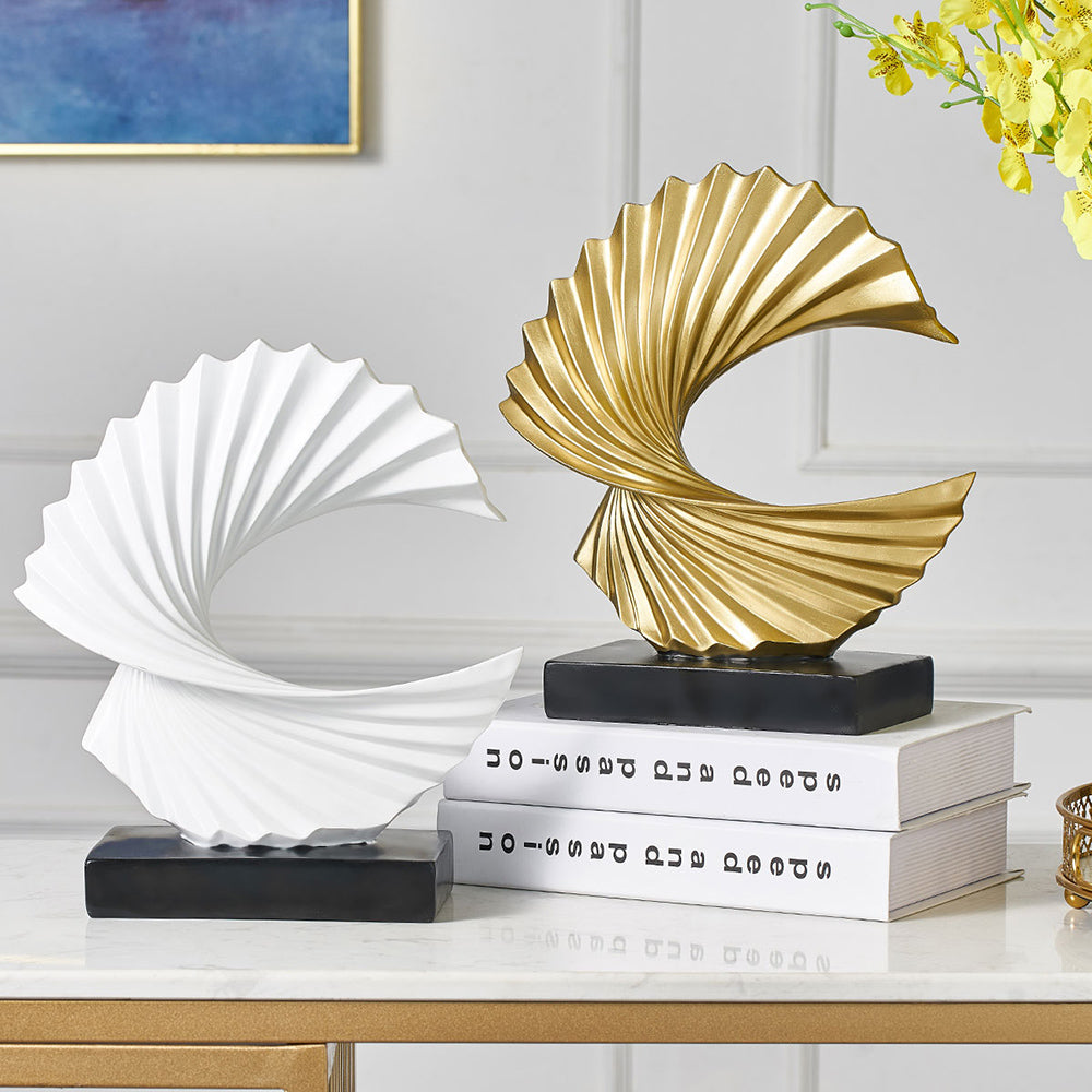 Decorative sculptures on books with a gold and white color scheme in a room setting.