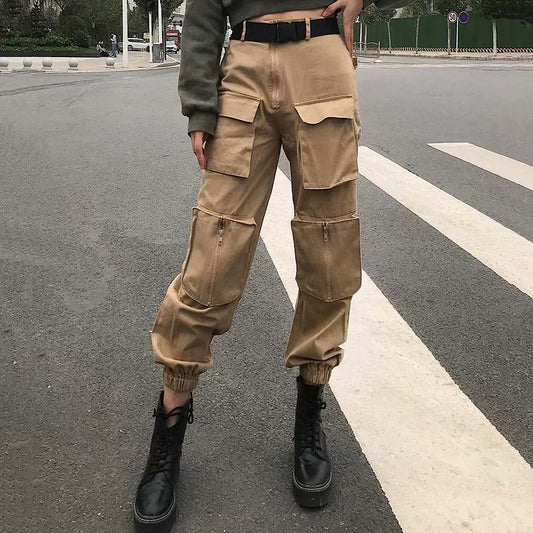 Person wearing beige cargo pants and black boots on a street.