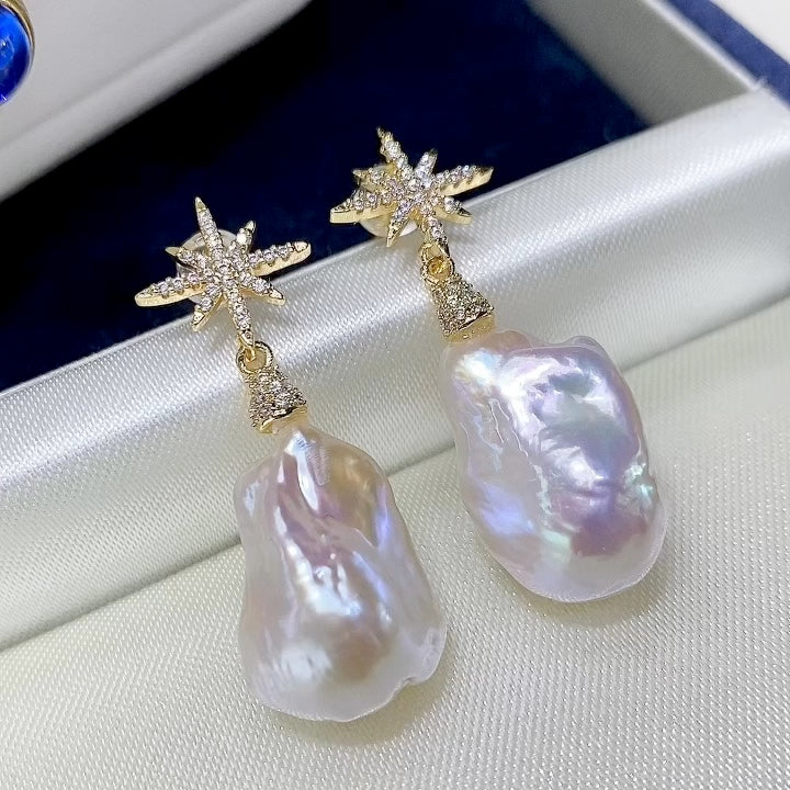 Pearl earrings with star-shaped tops on a soft fabric background
