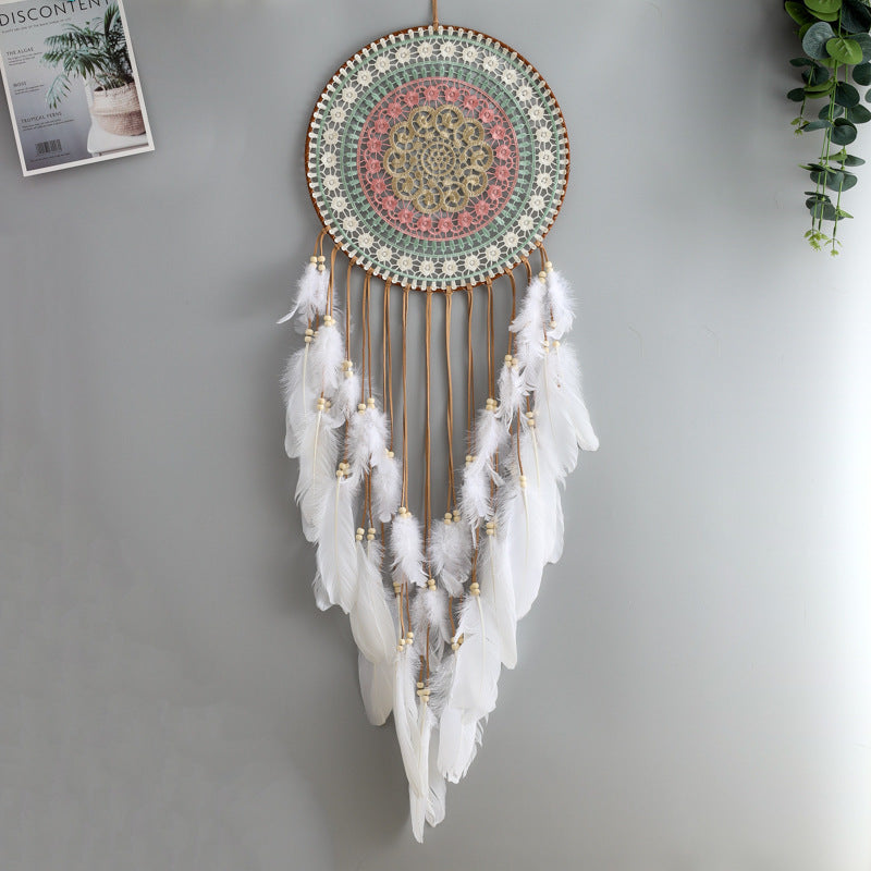 Decorative dreamcatcher with feathers against a gray wall
