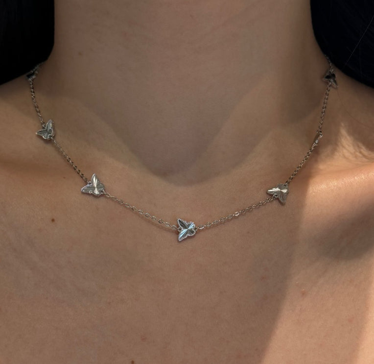 Butterfly-shaped necklace on a person's neck
