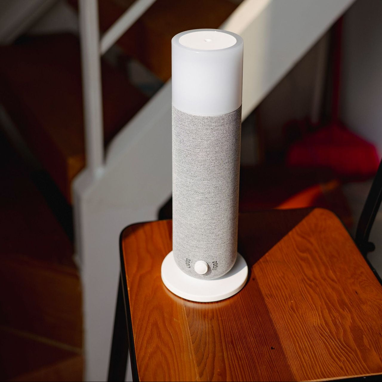 Smart speaker on a wooden stool with stairs in the background