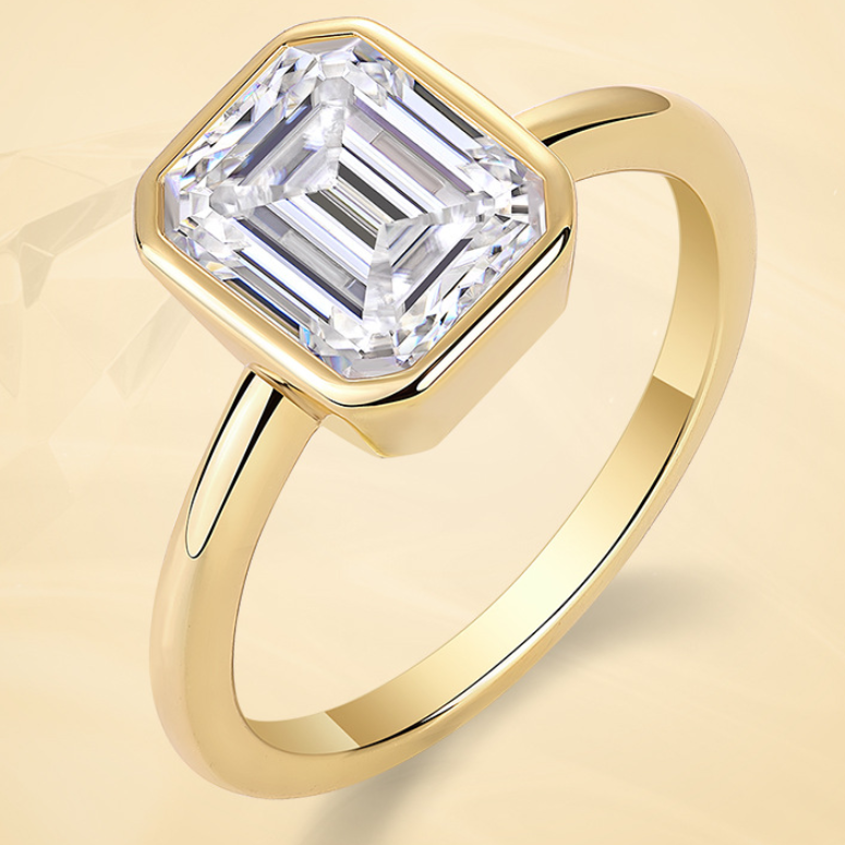 Gold ring with a large diamond on a beige background