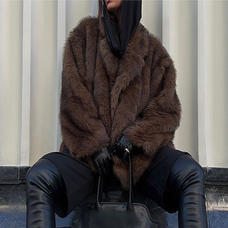 Person wearing a brown fur coat and black leather pants sitting on steps.