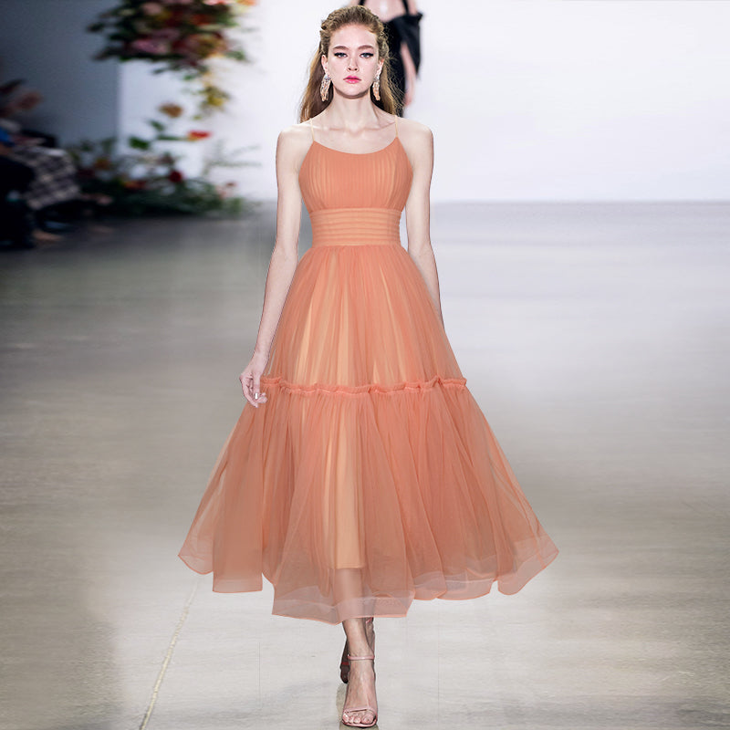 Model wearing a peach-colored dress on a runway