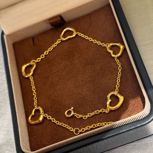 Gold bracelet with heart-shaped links in a jewelry box