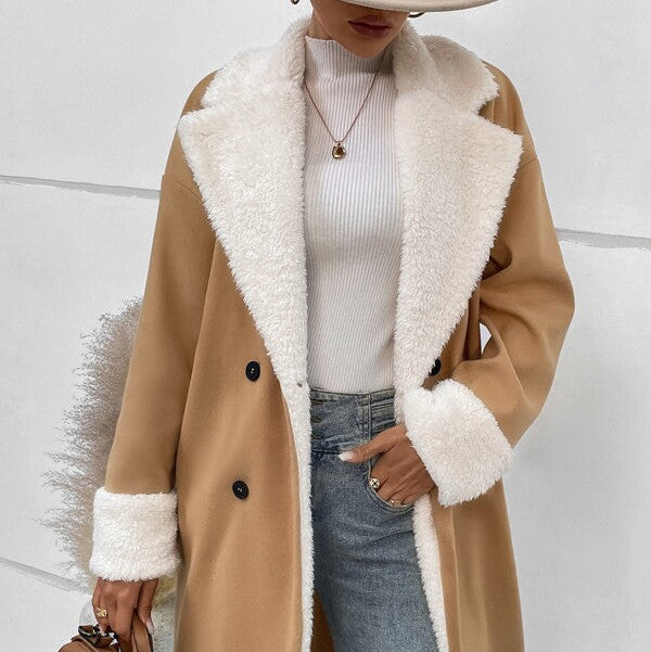 Person wearing a beige coat with white fur lining, holding a brown bag against a light background