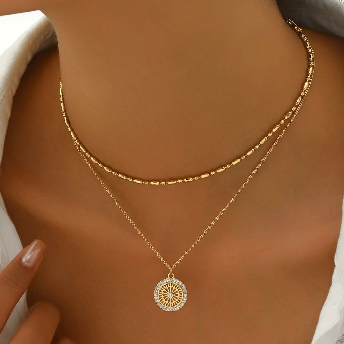 Gold necklace with a circular pendant on a person's neck