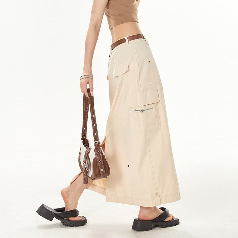 Woman wearing a brown crop top and beige skirt with sunglasses on a white background