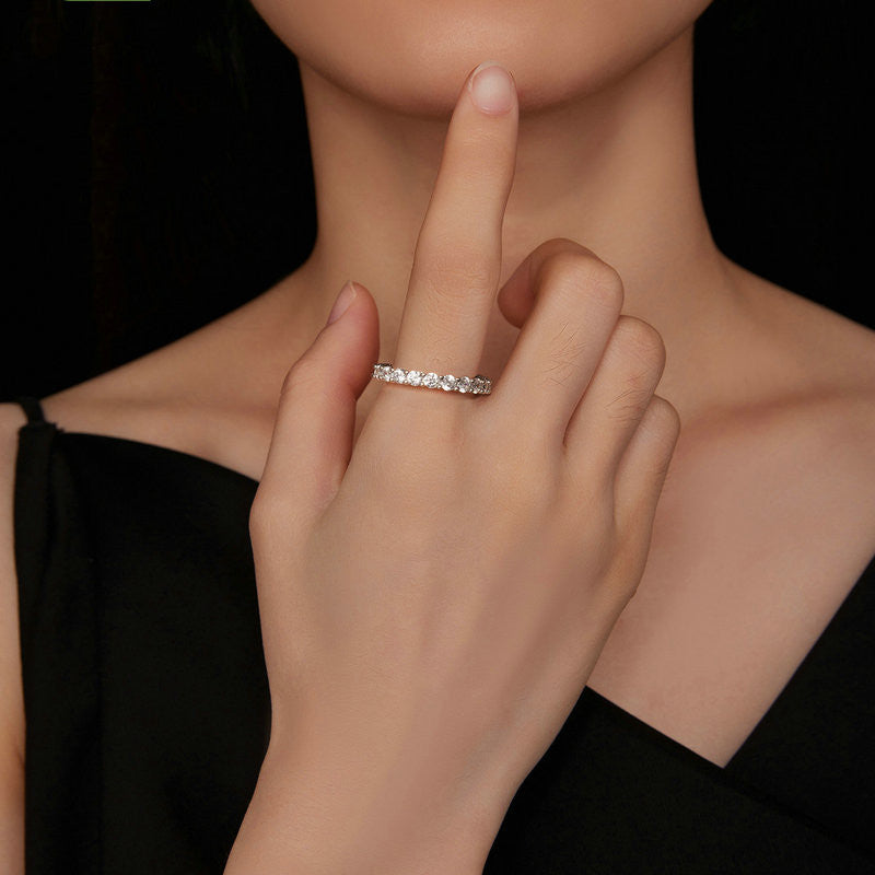 Close-up of a hand wearing a silver ring with a black background