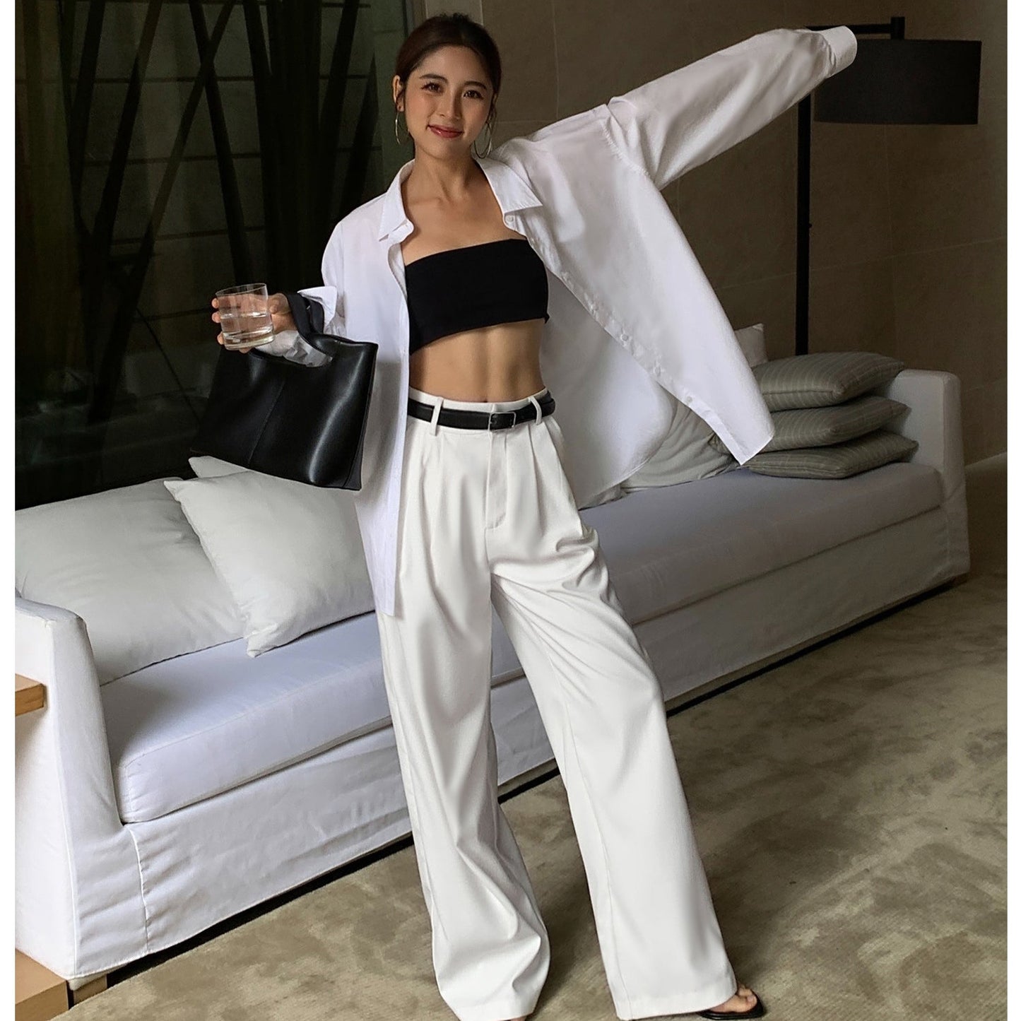 Woman in a stylish outfit posing in a modern living room.