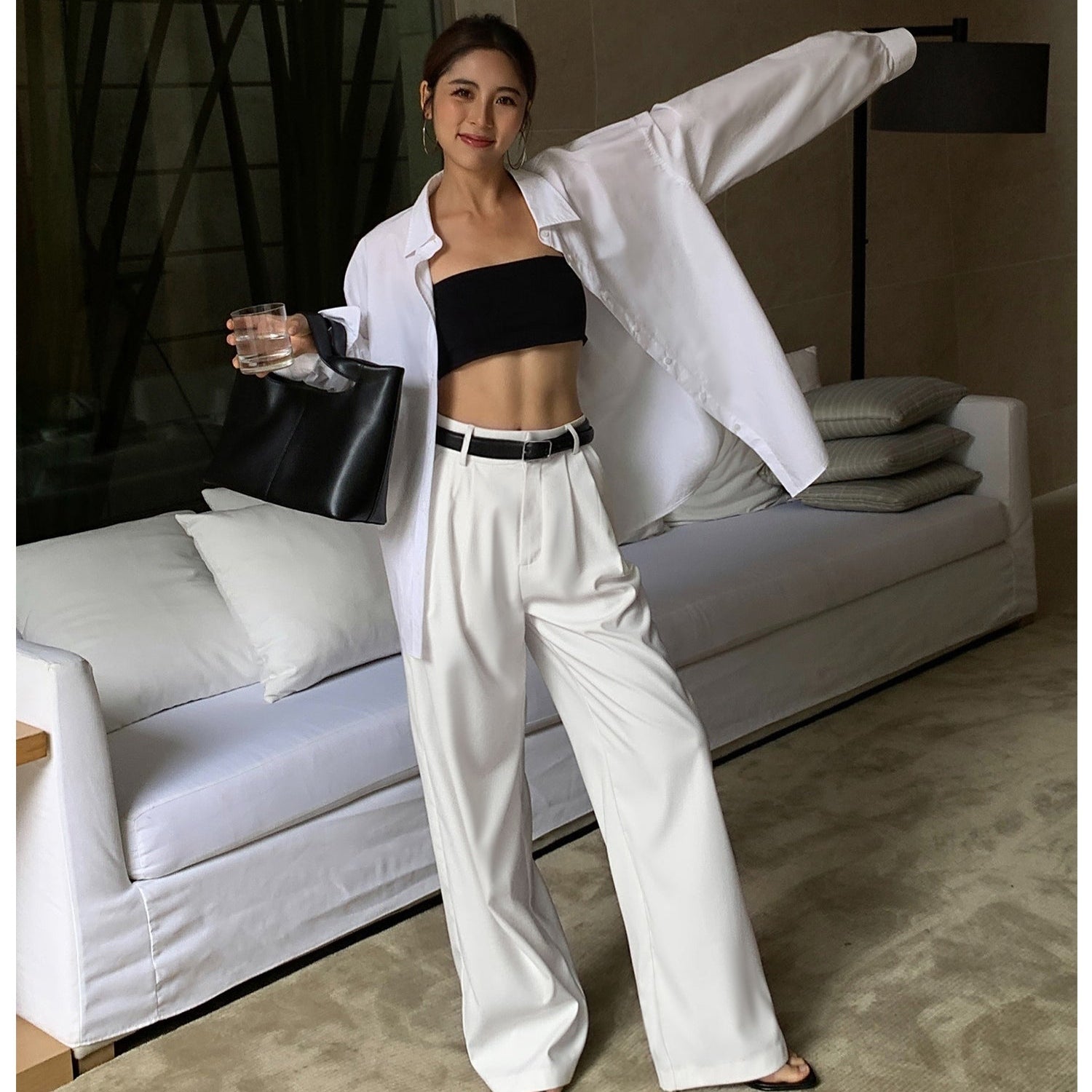 Woman in a stylish outfit posing in a modern living room.