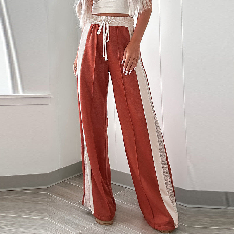 Person wearing red pants with white stripes in a minimal indoor setting