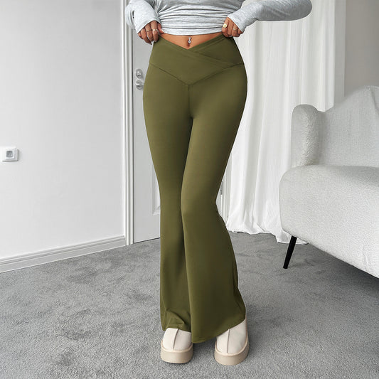 Person wearing olive green pants in a room with a white wall and gray carpet.