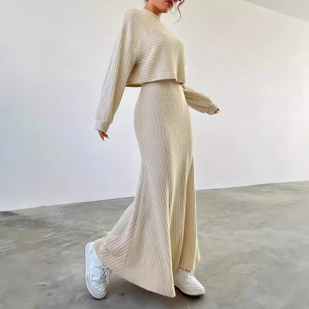 Person wearing a beige ribbed knit outfit with white sneakers in a minimalistic setting