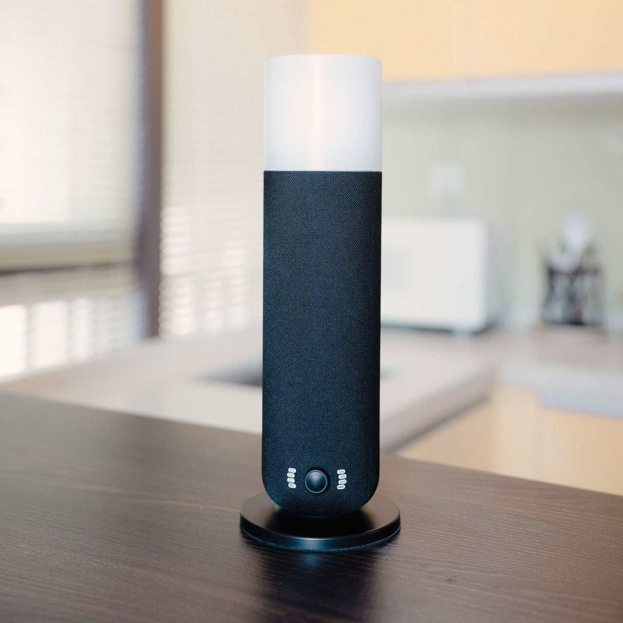 Black and white cylindrical device on a wooden surface with a blurred background