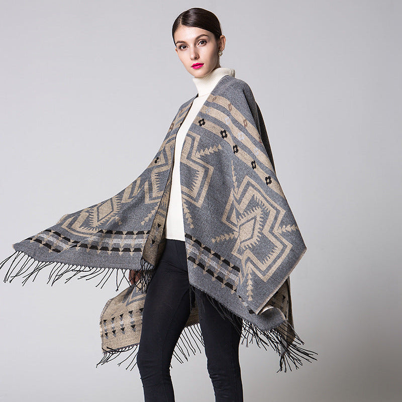 Woman wearing a patterned poncho against a plain background