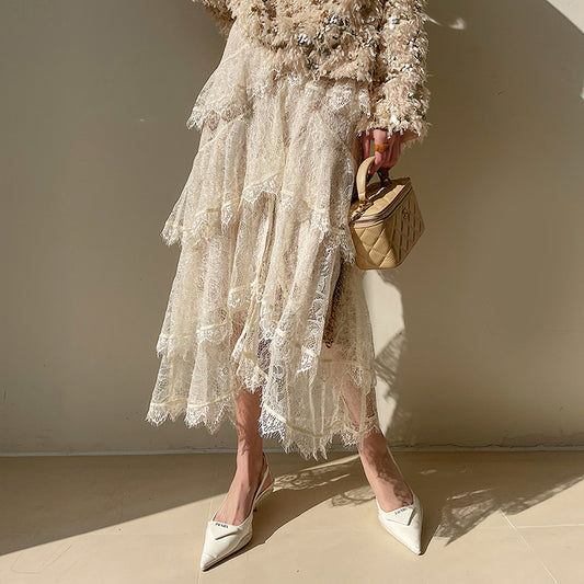 Person wearing a lace dress with a beige handbag against a neutral background