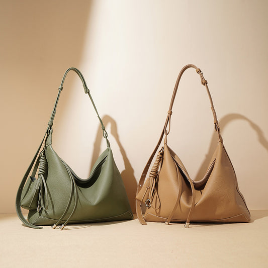Two handbags, one green and one beige, on a beige background