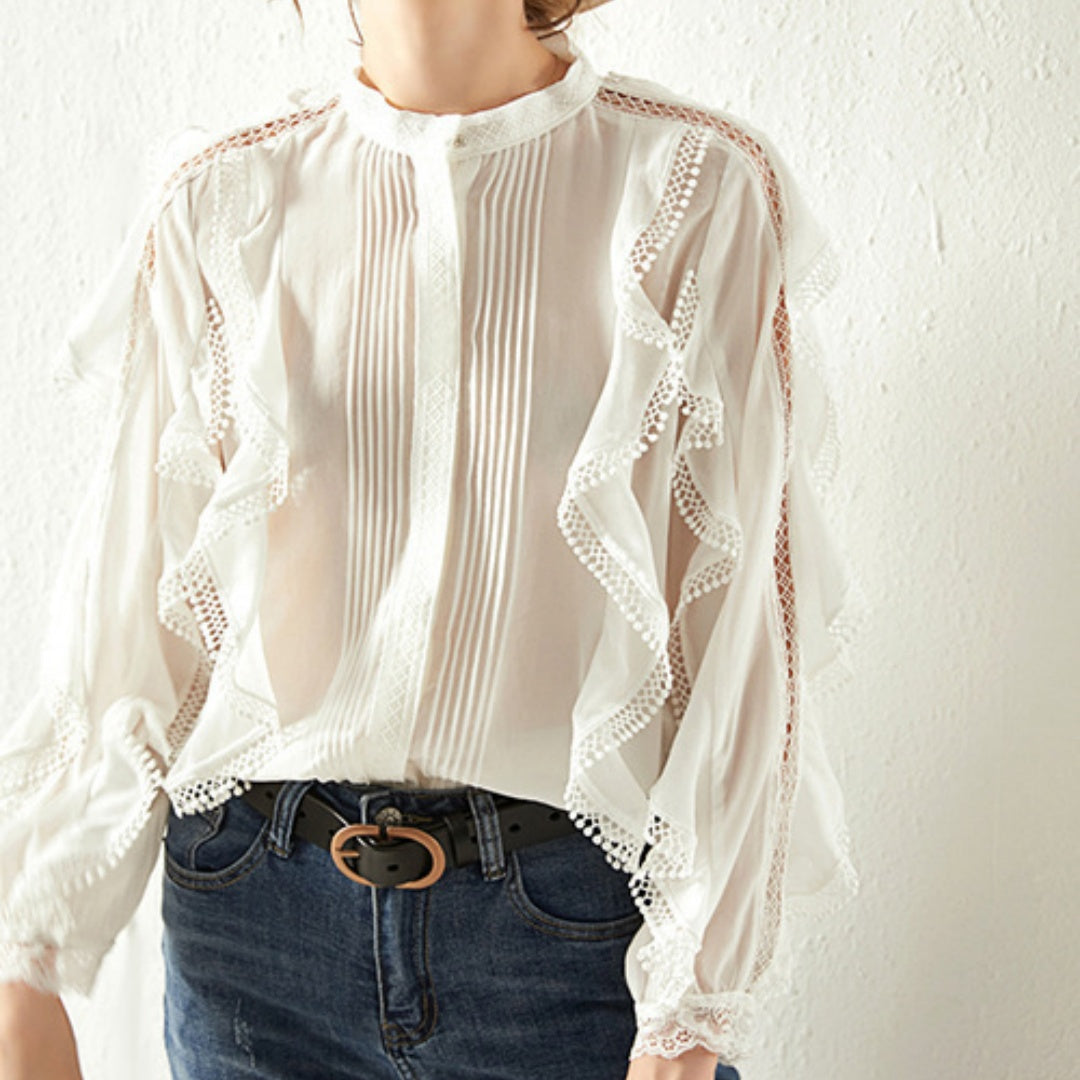 White lace-trimmed blouse worn by a person on a white background