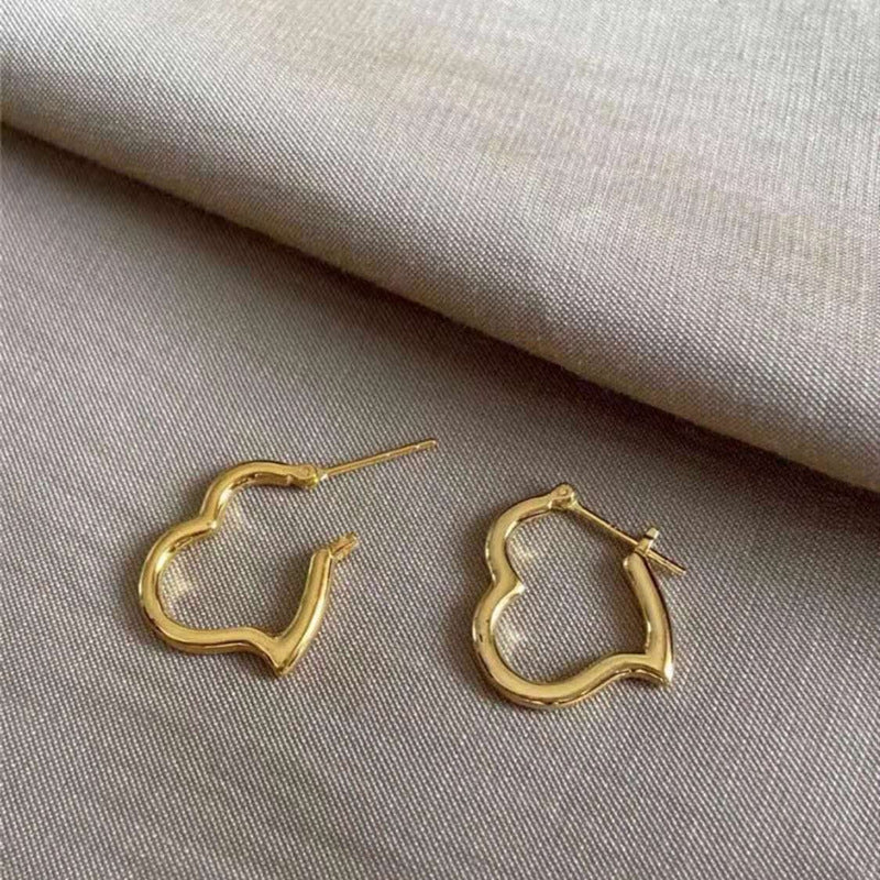 Gold hoop earrings on a textured fabric background