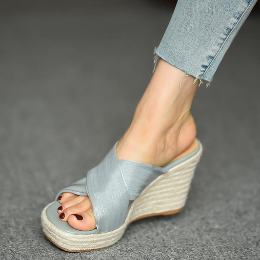 Light blue wedge sandal worn on a gray background