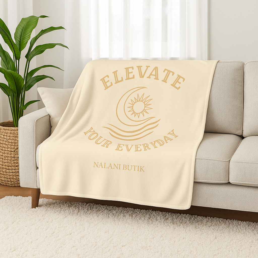 Beige blanket with 'Elevate Your Everyday' text on a beige couch.