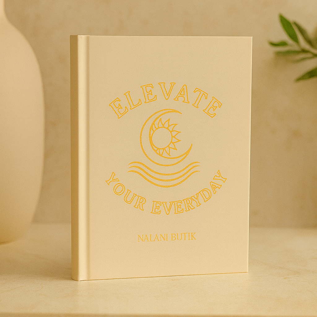 Beige notebook with 'Elevate Your Everyday' text on a wooden surface