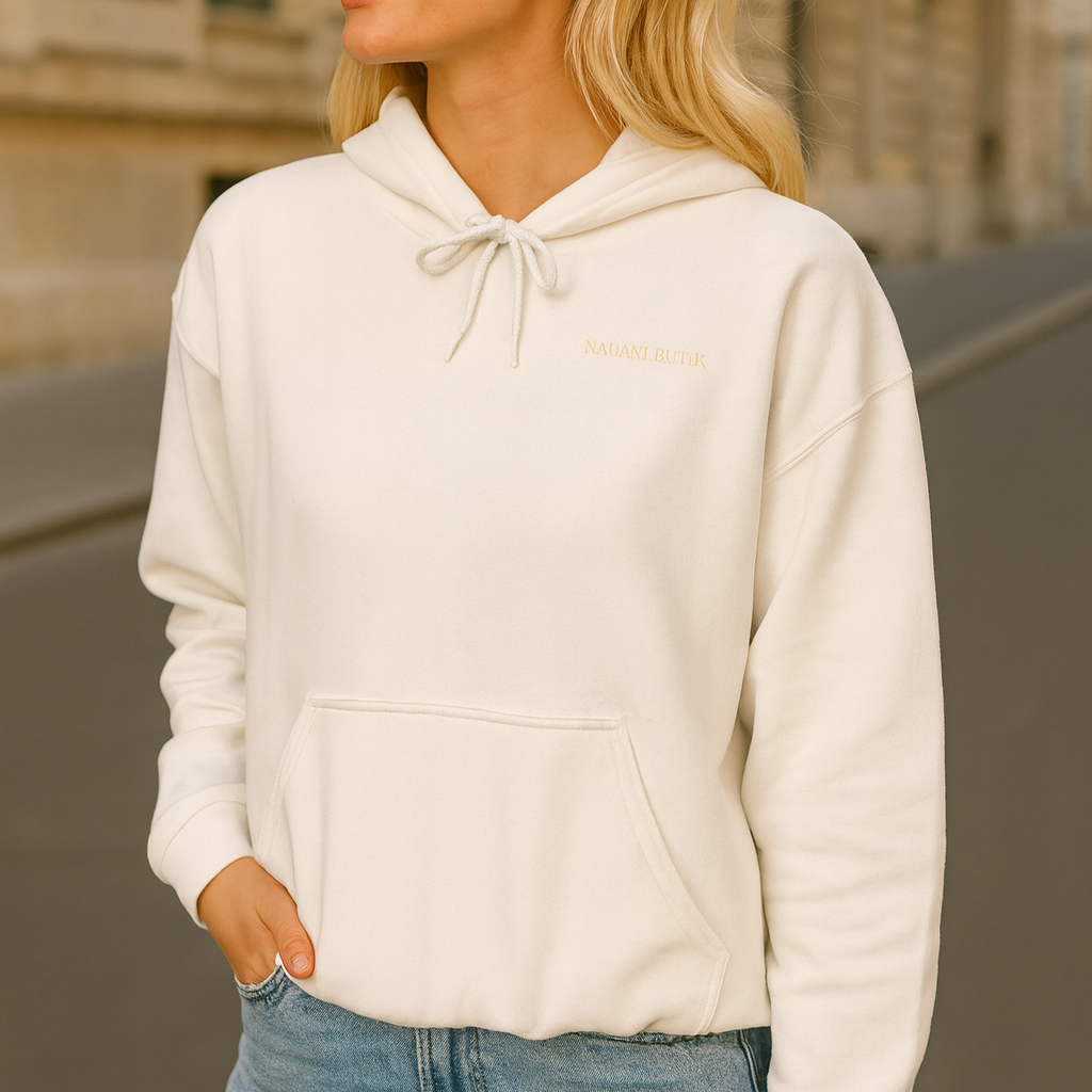 Woman wearing a white hoodie and sunglasses in an urban setting