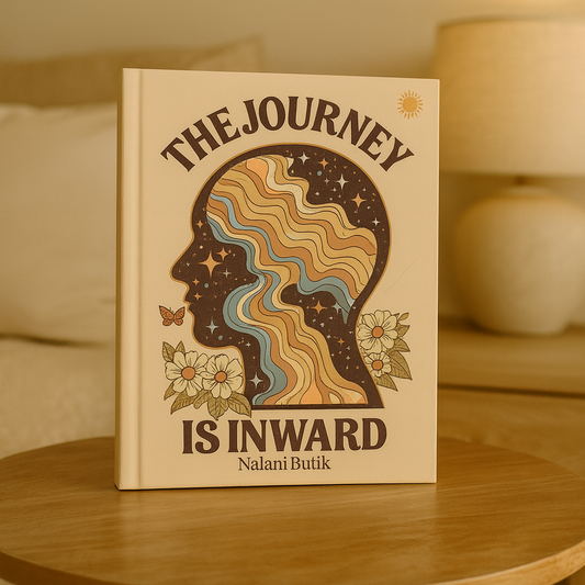 Book titled 'The Journey Is Inward' by Nalani Butik on a wooden table with a warm background.