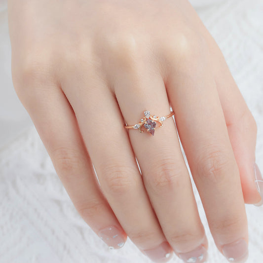 Rose gold ring with a star design on a hand against a white background