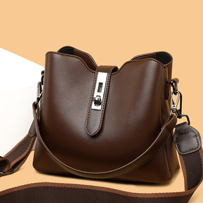 Brown leather handbag with a silver clasp on a beige background