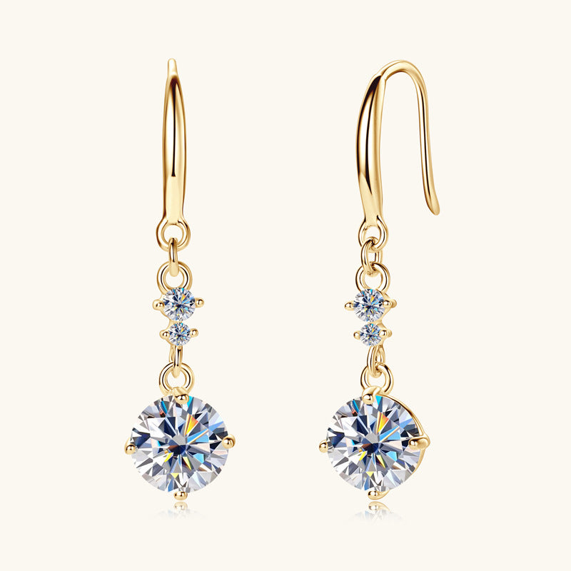 Gold earrings with clear gemstones on a white background