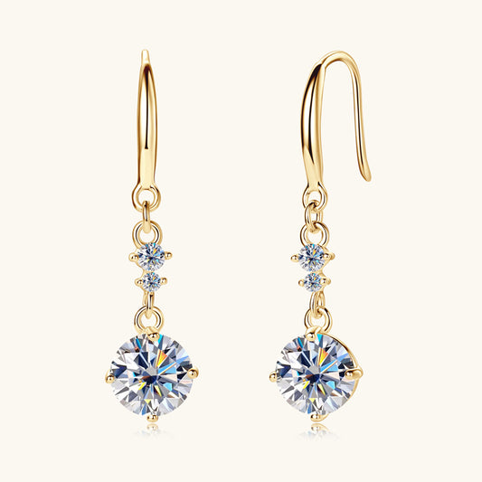 Gold earrings with clear gemstones on a white background