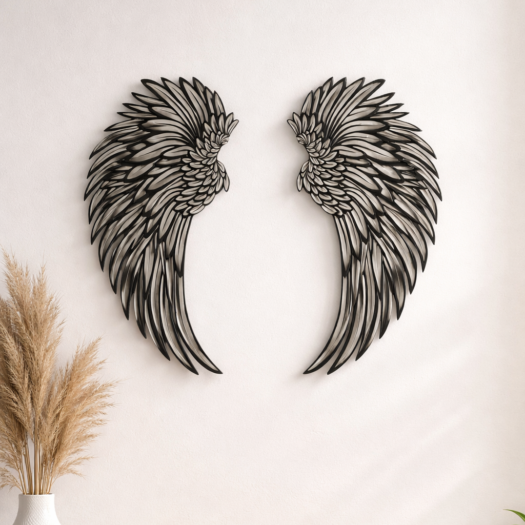 Metal angel wings wall decor on a white wall above a wooden cabinet.
