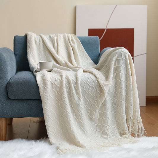 White textured blanket draped over a blue armchair in a cozy living room setting.
