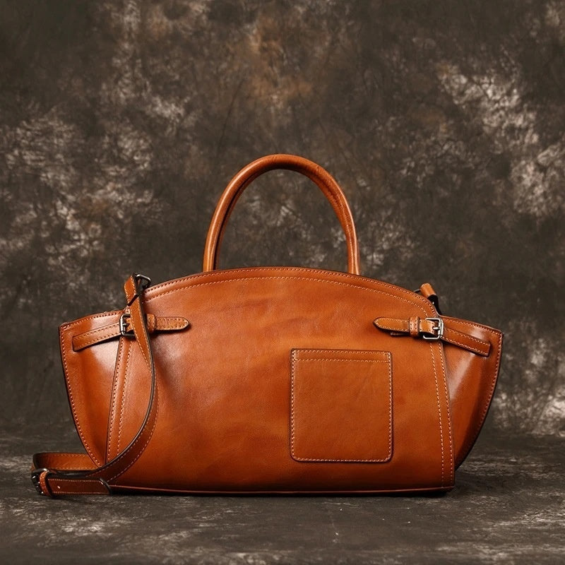 Brown leather handbag on a textured dark background
