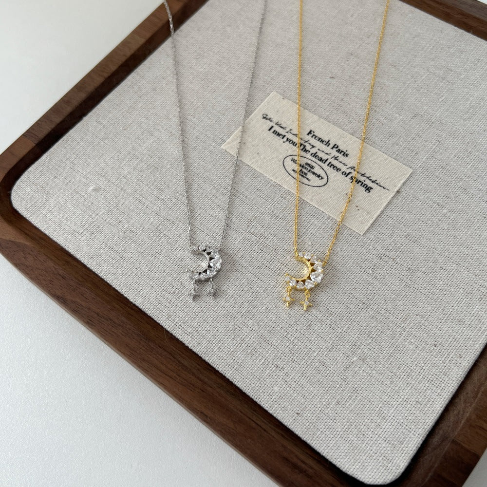 Two necklaces on a textured gray surface with a wooden frame