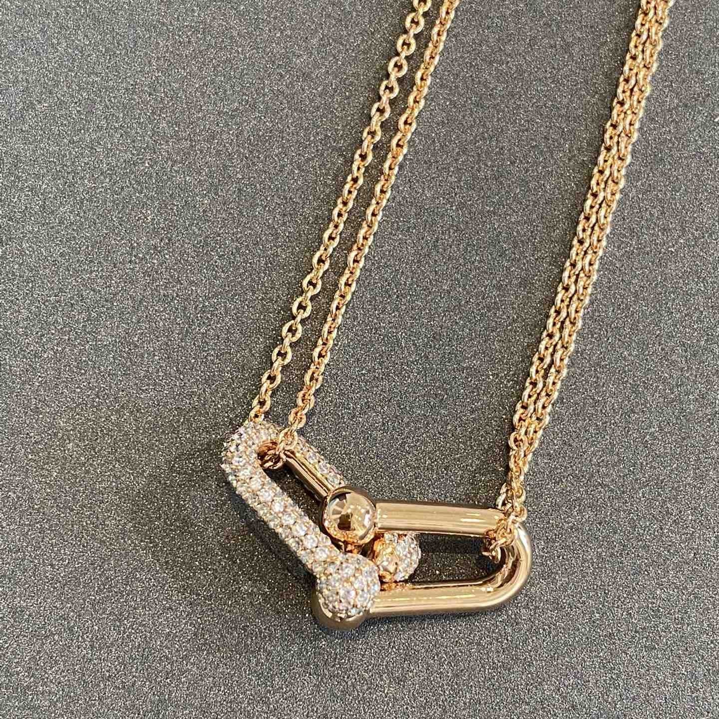 Gold necklace with a unique pendant on a gray background