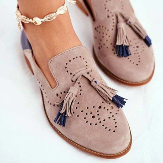 Beige loafers with tassels on a white background