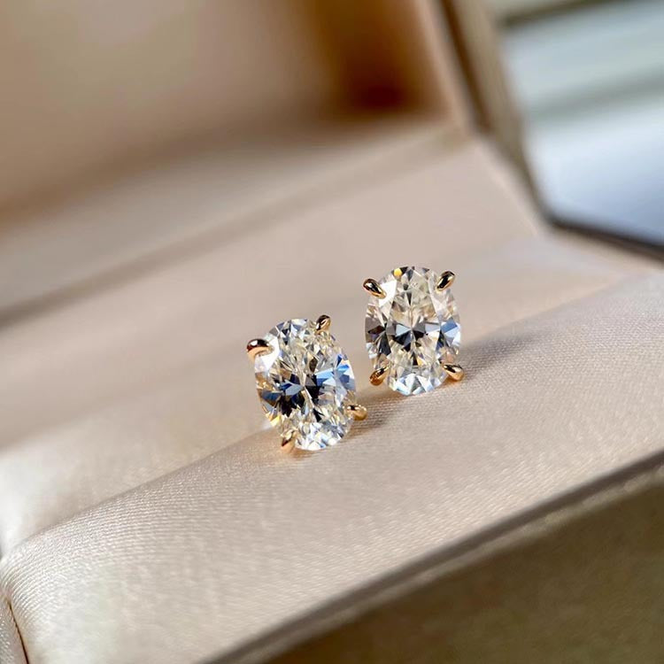 Pair of diamond stud earrings on a soft fabric background